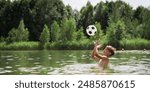 A little boy swims and plays in the lake with a ball