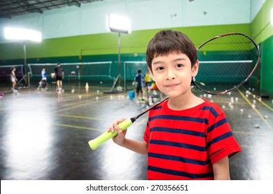 Little boy taking badminton racket in training class at the gym