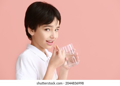 Little Boy Taking Fish Oil Pill On Color Background