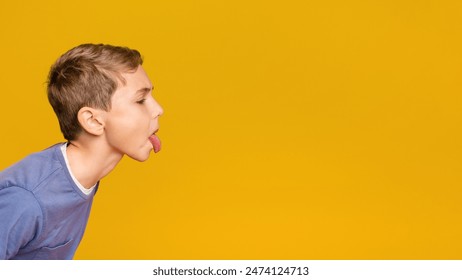 Little boy teasing someone, showing tongue and making face at free space aside, orange background - Powered by Shutterstock