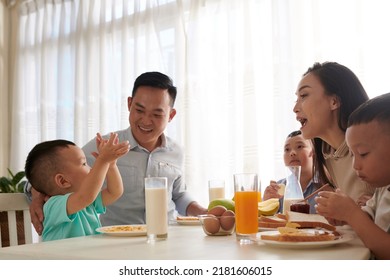 Little Boy Telling Story To His Family During Breakfast