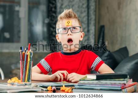 The little boy was thinking, sticking a sticker on his forehead.