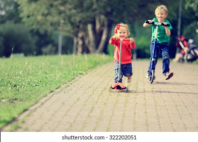 little boy and toddler girl riding scooters in summer park, kids sport - Powered by Shutterstock