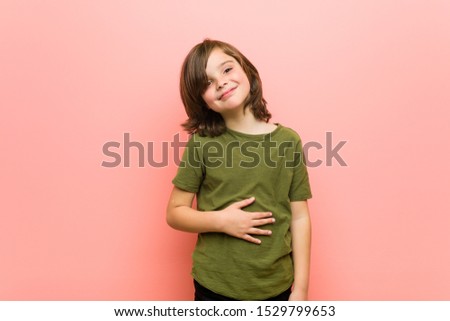 Little boy touches tummy, smiles gently, eating and satisfaction concept.