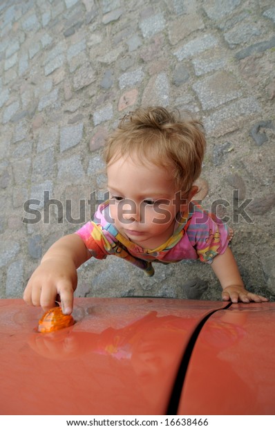 little\
boy is touching the direction indicator of a\
car