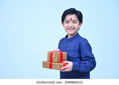 Little Boy In Tradional Clothes  Holding Gift Box Smiling  Studio Shot