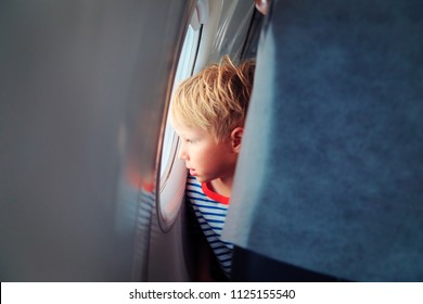 Little Boy Travel By Plane Looking Through Window