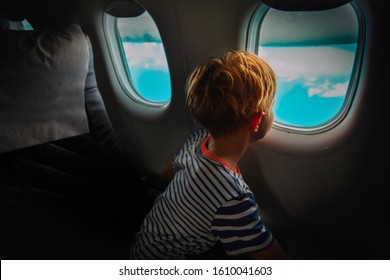 Little Boy Travel By Plane Looking Through Window