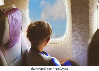 Little Boy Travel By Plane Looking Through Window