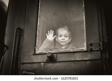 little boy is traveling on an old train