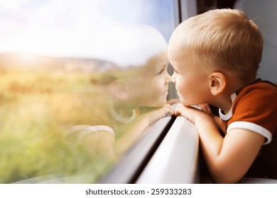Little Boy Traveling In Train Looking Outside The Window.
