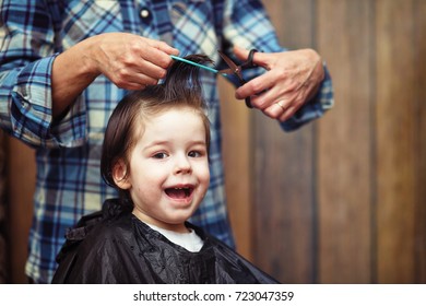 A little boy is trimmed in the hairdresser's bright emotions on his face