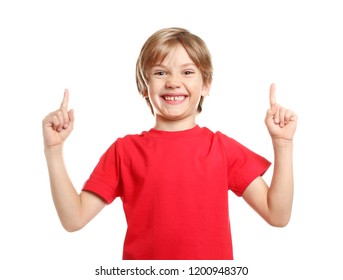 Little boy in t-shirt pointing at something on white background