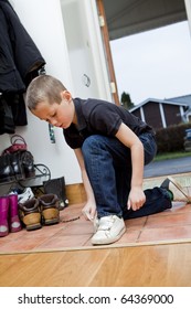 Little Boy Tying His Shoes Before He Gets Outdoor