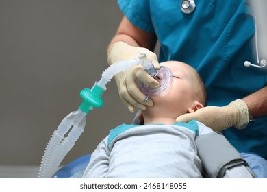 The little boy is under general anesthesia. A breathing tube in the baby's mouth. Surgical intervention. Dental treatment under general anesthesia. Photo in the operating room. - Powered by Shutterstock