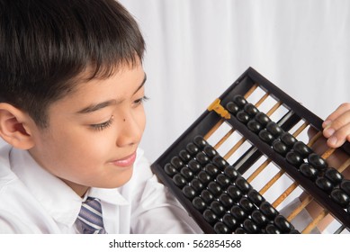 Little boy using abacus to study mathematics education class