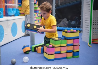 Little Boy Using Blocks Building Rocket. Kids Learning And Development Concept. Sensory Room, Independent Play