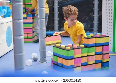 Little Boy Using Blocks Building Rocket. Kids Learning And Development Concept. Sensory Room, Independent Play