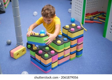 Little Boy Using Blocks Building Rocket. Kids Learning And Development Concept. Sensory Room, Independent Play