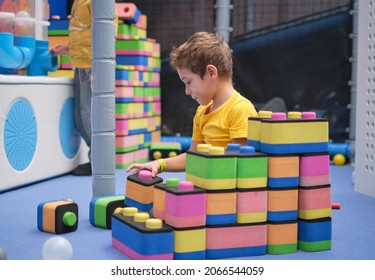 Little Boy Using Blocks Building Rocket. Kids Learning And Development Concept. Sensory Room, Independent Play