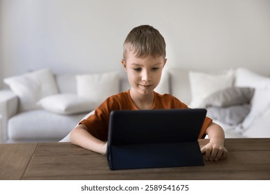 Little boy using digital tablet device at home, watching cartoons, engaged in gaining new knowledge through online platform or app for children. Parental control software for kids safety, games, fun
