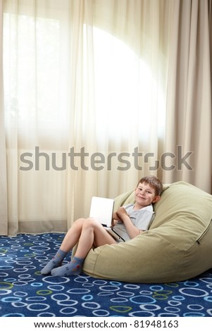 Similar – young caucasian little boy playing with tablet on couch