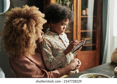 Little Boy Using Phone During Dinner