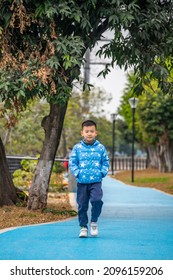 A Little Boy Walking On The Park Path