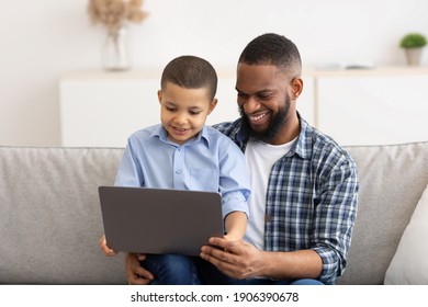 Little Boy Watching Movie On Tablet Sitting On Dad's Knees, Using Computer Together And Browsing Internet At Home. Gadgets, Weekend Family Leisure Concept - Powered by Shutterstock