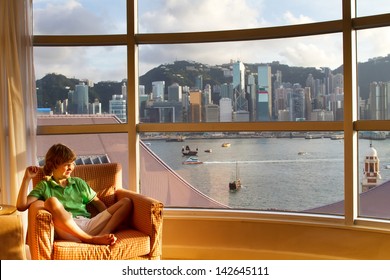 Little Boy Watching The View Of The Hong Kong Bay Out Of A Hotel