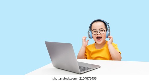 Little boy wearing headphones using laptop, happy learning,  listening audio course, e-learning education concept - Powered by Shutterstock