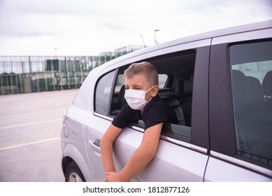 Little boy wearing respirator mask looking through a car window, stop travel, self-isolation during quarantine, stay safe 