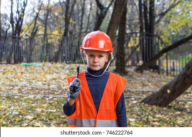 Little Boy Wearing Tradesman Oversize Uniform And Safety Hat - One Size Doesn't Fit All