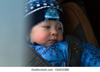 Little Boy In Winter Clothes In A Child Car Seat Close-up