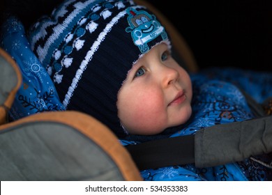 Little Boy In Winter Clothes In A Child Car Seat Close-up