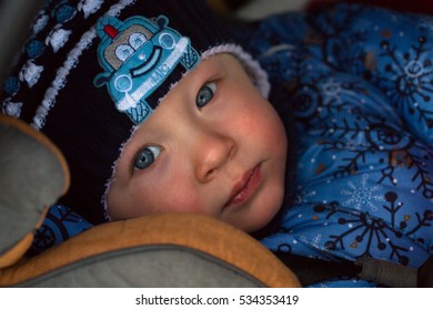 Little Boy In Winter Clothes In A Child Car Seat Close-up