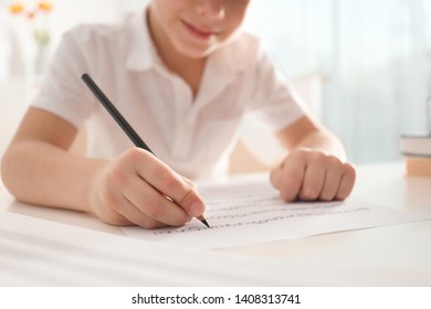 Little boy writing music notes at table, closeup