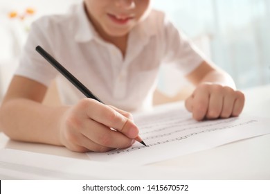 Little Boy Writing Music Notes At Table, Closeup