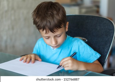 Little Boy Writing On Blank Paper