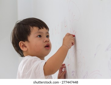 Little Boy Writing  On Wall Background