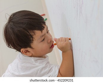 Little Boy Writing  On Wall Background