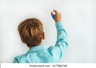 The Little Boy Writing On The White Wall