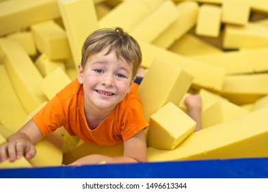 Little boy in yellow gymnastic foam pits