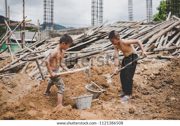 Little boys labor working\
in commercial building structure, World Day Against Child Labour\
concept.