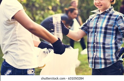 Little Boys Picking Up Plastic Bottle In The Park Volunteer Community Service