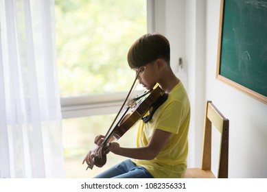 Little Boys Play And Practice Violin In The Music Class Room