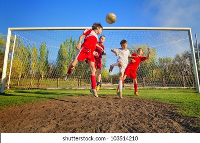 Little Boys Playing Soccer On The Sports Field Next To Goal