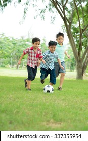 Little boys playing soccer in the park