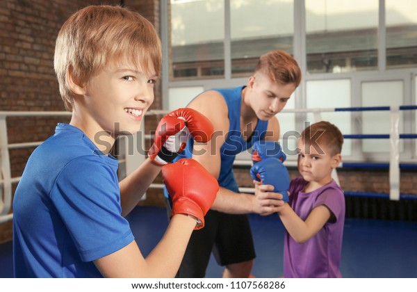 Thrilled Young Boy Giggling With Boxing Gloves Up For 