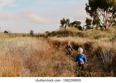 Little boys walking along dry creek bed. Adventures in nature.